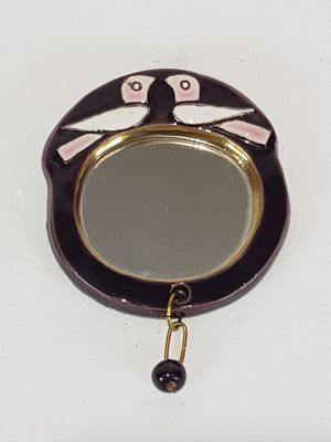 un petit miroir orné d'un chat, accroché au mur