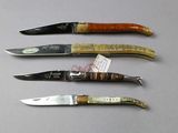 four knives are lined up in a row on a table