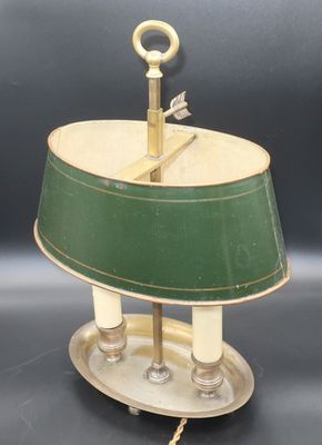une lampe à l'ancienne surmontée d'un abat-jour vert