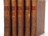 three old books are stacked on top of each other on a white surface