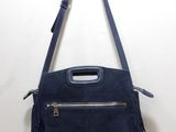 a blue purse hanging from a hook on a wall