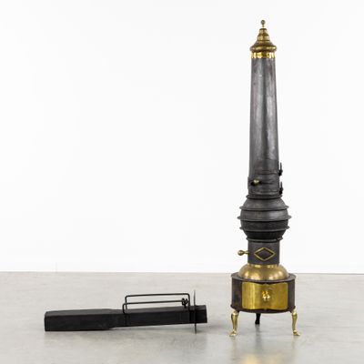 une image représentant une horloge noire et dorée avec un stylo posé par terre