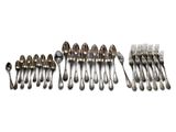 un grand nombre de cuillères et de fourchettes en argent sur une surface blanche