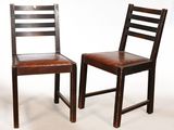 une paire de chaises en bois avec des assises en cuir marron sur fond blanc