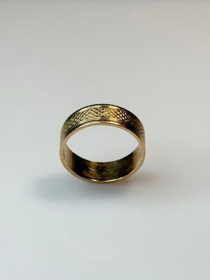 a close up of a gold ring on a white surface