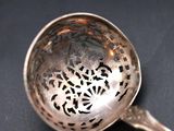 a silver spoon with a design on it on a black surface