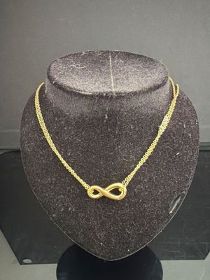Collier « infini » plaqué or présenté sur un mannequin d'exposition