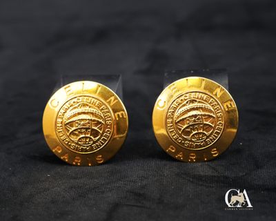 une paire de boucles d'oreilles plaquées or sur fond noir