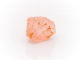 a close up of a pink rock on a white surface