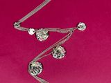 a close up of a necklace on a pink background