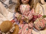 a doll that is sitting on a bed with a hat