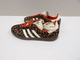 a pair of leopard print adidas sneakers with orange laces
