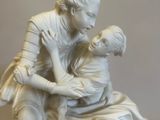 a statue of a man and a woman sitting on a bench