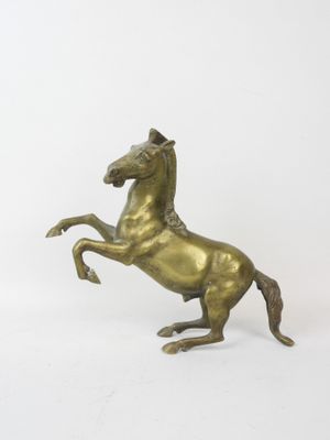 brass statue of a horse on its hind legs on a white background