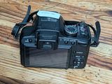 a camera sitting on a wooden table with a strap around it