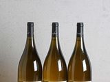 trois bouteilles de vin posées sur une table en bois