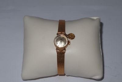 a watch on a pillow on a white surface