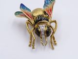 a close up of a gold and enamel insect broochle