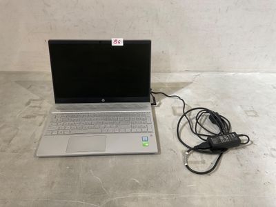 un ordinateur portable posé par terre avec son chargeur