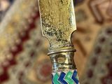 someone is holding a knife in their hand on a rug