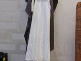 a white dress hanging on a clothes rack in a room