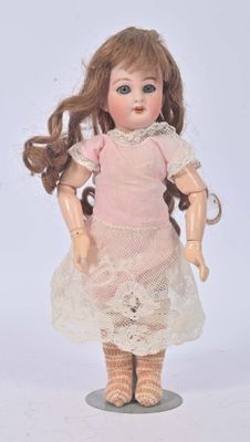 a small doll that is wearing a pink dress