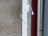 une borne d'incendie rouge posée sur le trottoir, à côté d'un immeuble