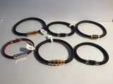 six bracelets différents, munis d'étiquettes, posés sur une table