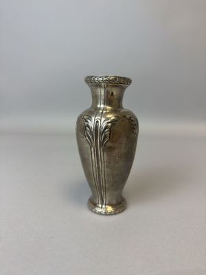 un vase en argent posé sur une table