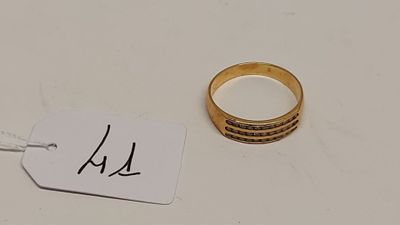 une bague en or et une étiquette posées sur une table blanche