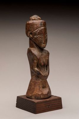 une statue en bois d'une femme avec un chapeau sur la tête