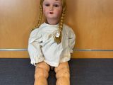 a doll that is sitting on the floor in front of a wall