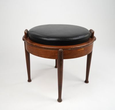 a wooden stool with a black leather seat on it