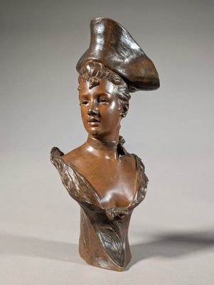 bronze bust of a woman with a hat on her head