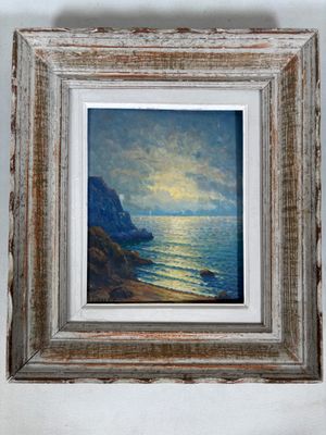 une peinture à l'huile représentant un coucher de soleil sur l'océan, dans un cadre en bois