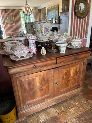 a lot of dishes on a wooden table in a room
