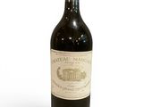 une vieille bouteille de vin posée sur une table blanche