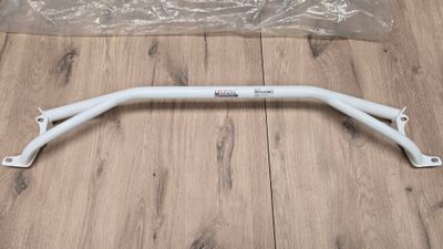 a close up of a white handle bar on a wooden floor