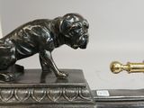 bronze figurine of a dog on a desk with a pen in its mouth