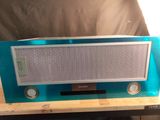 une radio bleue posée sur une table en bois