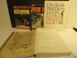 Plusieurs livres sont posés sur une table, à côté d'un stylo et d'un livre