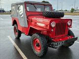 a red jeep parked in a parking lot on a cloudy day