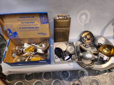 une boîte remplie de cuillères en argent et d'autres couverts en argent posée sur une table