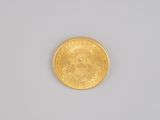 a close up of a gold coin on a white surface