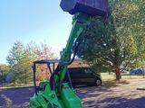 a small green tractor with a bucket on top of it