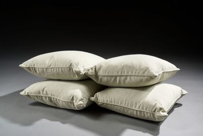 three white pillows stacked on top of each other on a table
