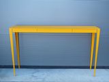une photo d'une console jaune placée contre un mur