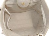 beige and white handbag with gold hardware on the handle