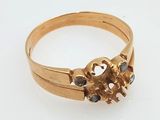 an image of a gold ring with black stones on it