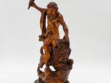 an image of a statue of a man on a rock with a hammer